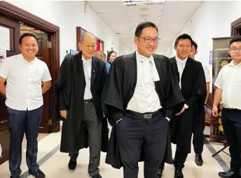  ?? ?? Kong (left), together with Chieng Jen (third left) and his legal team, are met by the press outside the courtroom.