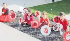  ??  ?? Lily Allen
(5), Bryn Moir (4), Chevelle Cook (4), and Mason Richards
(4) sit among the poppies they made.