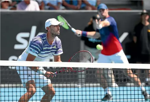  ?? GETTY IMAGES ?? Japan’s Ben McLachlan, left, waits at the net during the first set of his double match with Luke Bambridge, right, of Great Britain, during their 7-6 7-6 win over Sander Gille and Joran Vliegen, of Belgium, in the ASB Classic men’s doubles semifinal in Auckland yesterday. For the latest on the Classic go to stuff.co.nz.