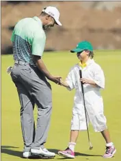  ?? Erik S. Lesser
European Pressphoto Agency ?? TIGER WOODS congratula­tes daughter Sam after she putted on the eighth hole during the par-three contest at Augusta National.