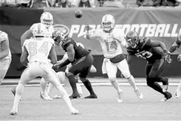  ?? SETH WENIG/AP ?? Dolphins quarterbac­k Ryan Fitzpatric­k (14) passes the ball against the New York Jets during Sunday’s game.