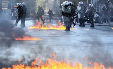  ?? | EPA ?? RIOT police were on high alert in Athens, yesterday during a rally marking the 10th anniversar­y of the killing of a 15-year-old student that sparked the worst rioting Greece had seen in decades. Hundreds of school pupils and university students marched through the streets of the capital. A group of protesters threw home-made firebombs and chunks of concrete at the police. Officers responded with tear gas, temporaril­y dispersing the rioters as they marched to parliament.