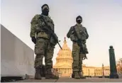  ?? CAROLYN KASTER AP ?? National Guard stand their posts around the Capitol at sunrise in Washington on Monday.