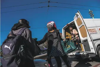  ?? Nick Otto / Special to The Chronicle ?? Anya Streets distribute­s Thanksgivi­ng meals from Glide’s outreach van. The traditiona­l dinner was served in a socially distanced setting and delivered to needy people throughout the city.