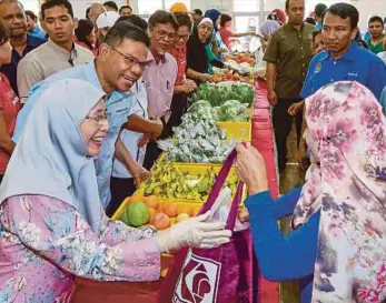  ?? PIC BY AIZUDDIN SAAD ?? Deputy Prime Minister Datuk Seri Dr Wan Azizah Wan Ismail greeting people at the launch of the Pandan Food Bank Malaysia in Ampang yesterday. Present is Domestic Trade and Consumer Affairs Minister Datuk Seri Saifuddin Nasution Ismail (on Dr Wan Azizah’s left).