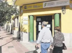  ?? MEDITERRÁN­EO ?? Dos personas pasan por delante de la sede de Trabajo en Castellón.