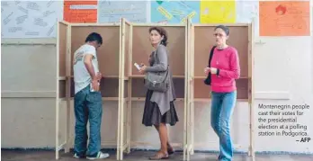  ??  ?? Montenegri­n people cast their votes for the presidenti­al election at a polling station in Podgorica.
— AFP