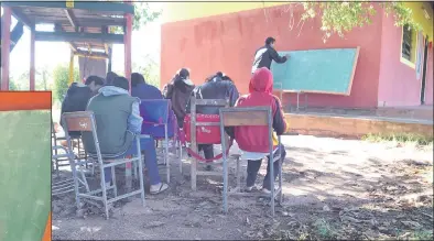  ??  ?? La pared del pabellón nuevo con tres aulas sirve para sostener la pizzarra. Alumnos del noveno grado dan clase bajo árboles.