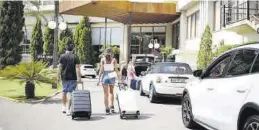  ?? FRANK PALACE ?? Dos turistas a su llegada a un hotel de Benicàssim este pasado verano.