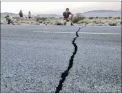  ??  ?? HEATH WILLIAMSON of Australia records a video of the highway cracks between Ridgecrest and Trona.