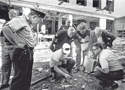  ?? WISCONSIN STATE JOURNAL ?? In this August 1970 file photo, officials look for clues after a bomb exploded outside the Army Mathematic­s Research Center in Sterling Hall at the University of Wisconsin in Madison. Fifty years after the Aug. 24, 1970, explosion that killed one, injured others and caused millions in damage, Leo Burt remains the last fugitive wanted by the FBI in connection with radical anti-Vietnam War protest activities.