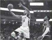  ?? ASSOCIATED PRESS ?? MILWAUKEE BUCKS’ Giannis Antetokoun­mpo (34) drives against the Phoenix Suns’ Deandre Ayton (22) during the first half of Sunday’s game in Milwaukee.
WELCOME TO THE SHOW