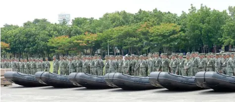  ?? — AFP ?? Philippine Marines stand next to rubber dingies during a handover ceremony of weapons from the US military, at Marine headquarte­rs in Manila on Monday.