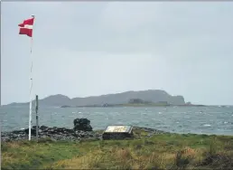  ??  ?? The Latvian flag flies in commemorat­ion on October 26, 2016, with the scene of the tragedy, Belnahua, behind.