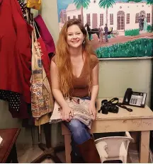  ??  ?? Kayleen Holder with her old writing desk built by her grandfathe­r Pat Dubose. In the background is a painting depicting the family tale of her Greatgreat Grandfathe­r W.L. Dubose, who traded a brand-new horse and buggy for the newspaper business in 1897.