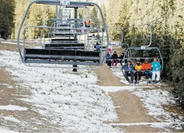  ?? LUIS SÁNCHEZ SATURNO/NEW MEXICAN FILE PHOTO ?? Bare ground can be seen in December as skiers ride the quad chair at Ski Santa Fe. Ski area officials hope the winter forecast for more snow proves to be true.