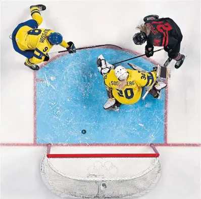  ?? ANTHONY WALLACE AFP VIA GETTY IMAGES ?? Canada’s Natalie Spooner scores past Sweden’s goaltender Emma Soderberg in quarterfin­al play Friday in Beijing.