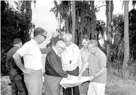  ?? SENTINEL FILE ?? Disney representa­tives view a map during a property inspection for Disney World at Lake Buena Vista. From left to right are E. Cardon Walker with sunglasses and white shirt, Roy Disney with sweater and glasses, Jack Sayer, an unidentifi­ed man and William Potter.