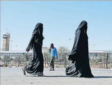  ?? MOHAMMED HUWAIS / AFP ?? Transeúnte­s frente al aeropuerto de Saná, donde ayer volvieron a aterrizar aviones con ayuda