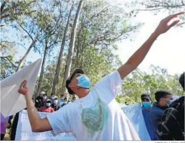  ?? RAMÓN DE LA ROCHA / EFE ?? Un migrante hace volar un avión de papel en la protesta contra las condicione­s del campamento de La Laguna (Tenerife).