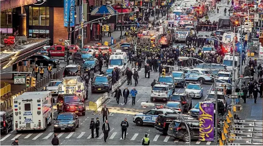  ??  ?? Police and emergency workers converge on the streets near New York City’s Times Square after a man set off a crude pipe bomb strapped to his body in a pedestrian underpass.