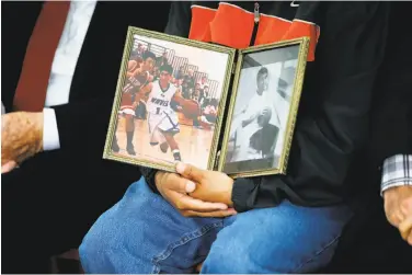  ??  ?? Manuel Gamboa holds a photo of his son, Kyle, 18, who died in 2013 after he jumped from the bridge.