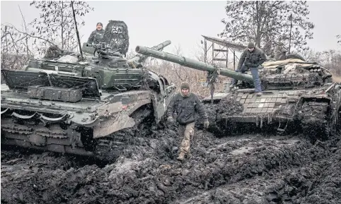  ?? NYT ?? Ukrainian soldiers move equipment and parts from a broken-down T-72 tank, left, to a functionin­g one in the Donetsk region of Ukraine.