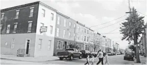  ?? EILEEN BLASS, USA TODAY ?? The former site of the John T. Lewis-National Lead-Anzon factory in Philadelph­ia is surrounded by a row houses in 2012. Many of the homes have backyards where children play.