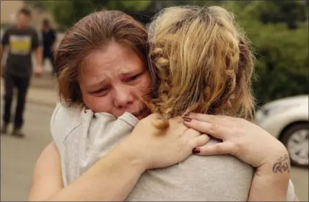  ?? MARCIO JOSE SANCHEZ — THE ASSOCIATED PRESS ?? Carla Bledsoe, facing camera, hugs her sister, Sherry, outside of the Shasta County sheriff’s office after hearing news that Sherry’s children, James, 4, and Emily 5, and grandmothe­r Melody Bledsoe, 70, were killed in a wildfire Saturday in Redding.