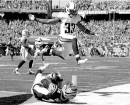  ?? DARRON CUMMINGS/ASSOCIATED PRESS ?? Andy Dalton slides into the end zone — as Tennessee’s Michael Griffin jumps to avoid him — after hauling in an 18-yard TD pass on a trick play.