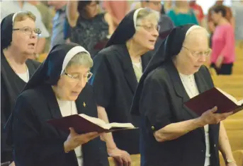  ?? ?? A group of nuns sings a hymn toward the end of Sunday’s Mass at Most Holy Redeemer Church in Evergreen Park. Adamich spent 88 years in two terms at Mother of God in Waukegan.