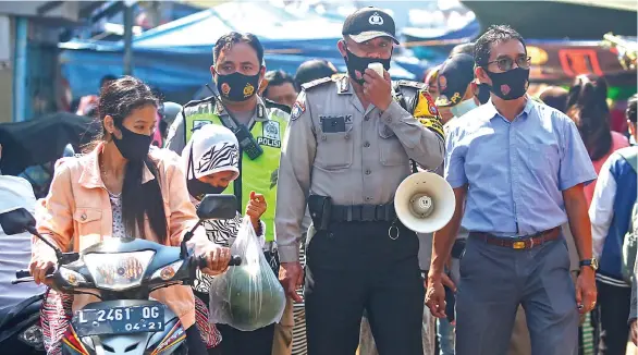  ?? AHMAD KHUSAINI/JAWA POS ?? AYO DISIPLIN: Petugas Bhabinkamt­ibmas Polsek Semampir bersama Satpol PP Kecamatan Semampir blusukan ke Wonokusumo Wetan untuk mengingatk­an warga supaya disiplin memakai masker kemarin (11/9). Selain menggencar­kan sosialisas­i, pemkot juga sedang menggodok sanksi bagi para pelanggar protokol kesehatan.