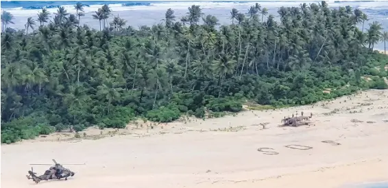  ??  ?? An Australian Army helicopter lands on Pikelot Island in Micronesia to rescue three men who had been stranded for three days.