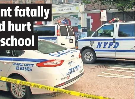  ?? AP ?? Police gather Wednesday near the front door of Urban Assembly School for Wildlife Conservati­on in New York, where a 15- year- old boy was stabbed to death and a 16- year- old injured in an attack.