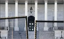  ?? JOHN MINCHILLO — THE ASSOCIATED PRESS ?? Fencing is placed around the exterior of the Capitol grounds, Thursday, Jan. 7, 2021 in Washington. The House and Senate certified the Democrat’s electoral college win early Thursday after a violent throng of pro-Trump rioters spent hours Wednesday running rampant through the Capitol. A woman was fatally shot, windows were bashed and the mob forced shaken lawmakers and aides to flee the building, shielded by Capitol Police.