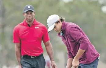  ?? ?? T iger Woods, izquierda, observa a su hijo Charlie, derecha, hacer un putt durante la ronda final del torneo de golf PNC Championsh­ip.