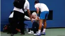 ??  ?? Novak Djokovic ayuda a la jueza de línea después de golpearla inadvertid­amente con una pelota en un arrebato de frustación.