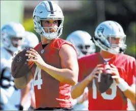  ?? Heidi Fang ?? Las Vegas Review-journal @Heidifang Quarterbac­ks Derek Carr, left, and Connor Cook release passes at the Raiders training camp in Napa, Calif.