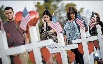  ?? JOHN LOCHER/AP ?? People visit a makeshift memorial for victims of the Vegas mass shooting. Millions of dollars have been raised in response.