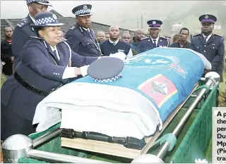  ?? (Pics: Mfanukhona Nkambule) ?? A police cap was placed on top of the casket carrying the body of Superinten­dent Dumisani Lawrence Dube, who was laid to rest at Mpolonjeni, Mbabane yesterday. (Pic above) The late Dube’s portrait.