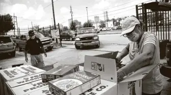  ??  ?? Catholic Charities’ Dhyaa Yousif, left, and Toni Romero prepare packaged food for distributi­on. Besides food aid, the group provides rental and utility-bill assistance to a variety of population­s.