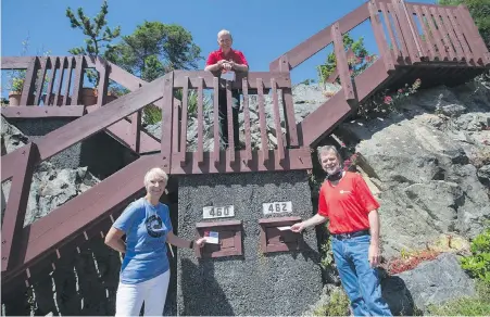  ??  ?? Esquimalt Mayor Barbara Desjardins, United Way Greater Victoria CEO Mark Breslauer, centre, and Seaspan Victoria Shipyards vice-president Joe O'Rourke Joe O’Rourke drop postcards into mailboxes seeking residents’ ideas.