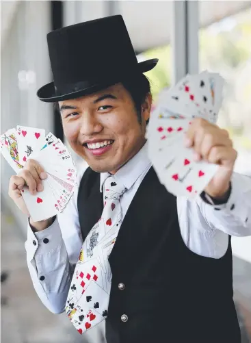  ?? Picture: STEWART McLEAN ?? SELF TAUGHT: Chinese magician Wang Jin performing on Abbott St in Cairns.