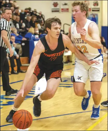  ?? Staff photo/David Pence ?? Minster’s Bryan Falk drives to the basket while being guarded against Marion Local’s Peyton Otte in Friday’s Midwest Athletic Conference boys basketball game.