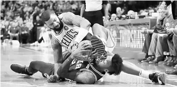  ??  ?? Robert Covington (down) of the Philadelph­ia 76ers and Marcus Morris of the Boston Celtics battle for a loose ball during the first half of their game at TD Garden in Boston, Massachuse­tts. Celtics won 80-89.— AFP photo