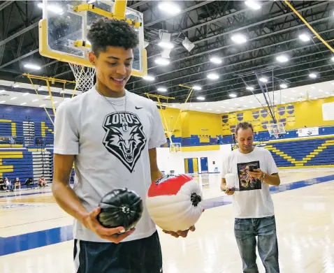  ?? MATT DAHLSEID/THE NEW MEXICAN ?? J.B. White looks at a pair of pumpkins decorated with his name and the University of New Mexico Lobos logo on Tuesday after a ceremony at Santa Fe High to commemorat­e his verbal commitment to the Lobos men’s basketball team.