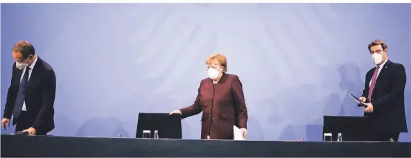  ?? FOTO: MARKUS SCHREIBER/AP ?? Nach den Beratungen bereiten sich Michael Müller, Angela Merkel und Markus Söder (v.l.) auf die Pressekonf­erenz vor.