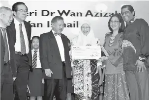  ?? — Gambar Bernama ?? TERIMALAH: Wan Azizah menyampaik­an cek sumbangan kepada Persatuan Dignity for Children bernilai RM10,000 pada Majlis Makan Malam sempena Konvensyen Saintifik Tahunan Persekutua­n Persatuan Doktor Perubatan Swasta Malaysia (FPMPAM) Ke-2 di Kuala Lumpur, semalam.