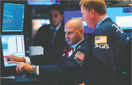  ?? JOHANNES EISELE/AFP/GETTY IMAGES ?? Traders work before the closing bell at the New York Stock Exchange on Wednesday in New York City on a day when stocks plummeted amid worsening economic fears.