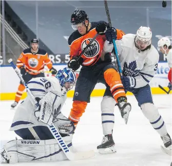  ?? THE CANADIAN PRESS ?? Edmonton Oilers’ Jesse Puljujarvi and Toronto Maple Leafs’ Justin Holl battle in front as Toronto goalie Jack Campbell makes the save in Edmonton on Saturday.